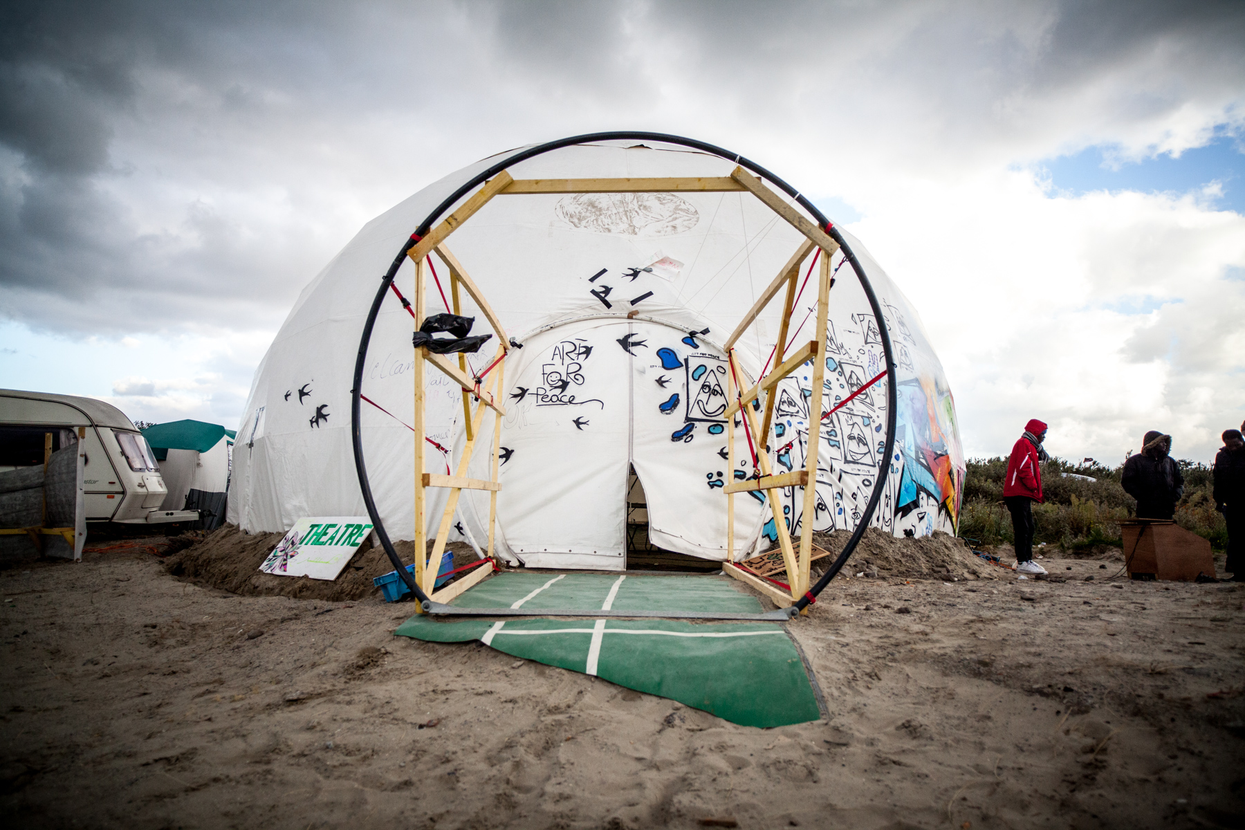  Un gigantesque dôme trône au fond de la jungle. Il a été construit par des britanniques. Il va accueillir des représentations théâtrales. C'est l'association britannique "Good Chance Calais" qui se charge de la structure.  Le Monde 23.10.15 