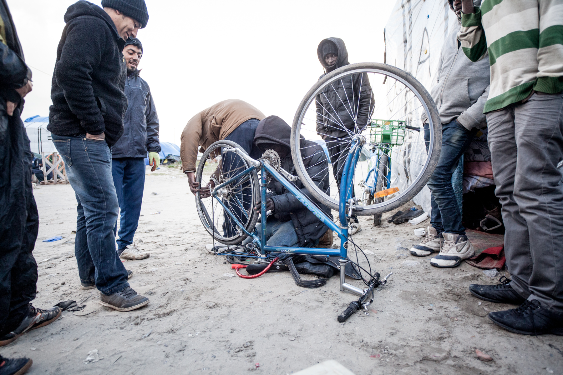  Dans la jungle, on utilise les sevices d'un autre migrant pour qu'il répare les vélos des autres.  Le Monde - 13.10.15 