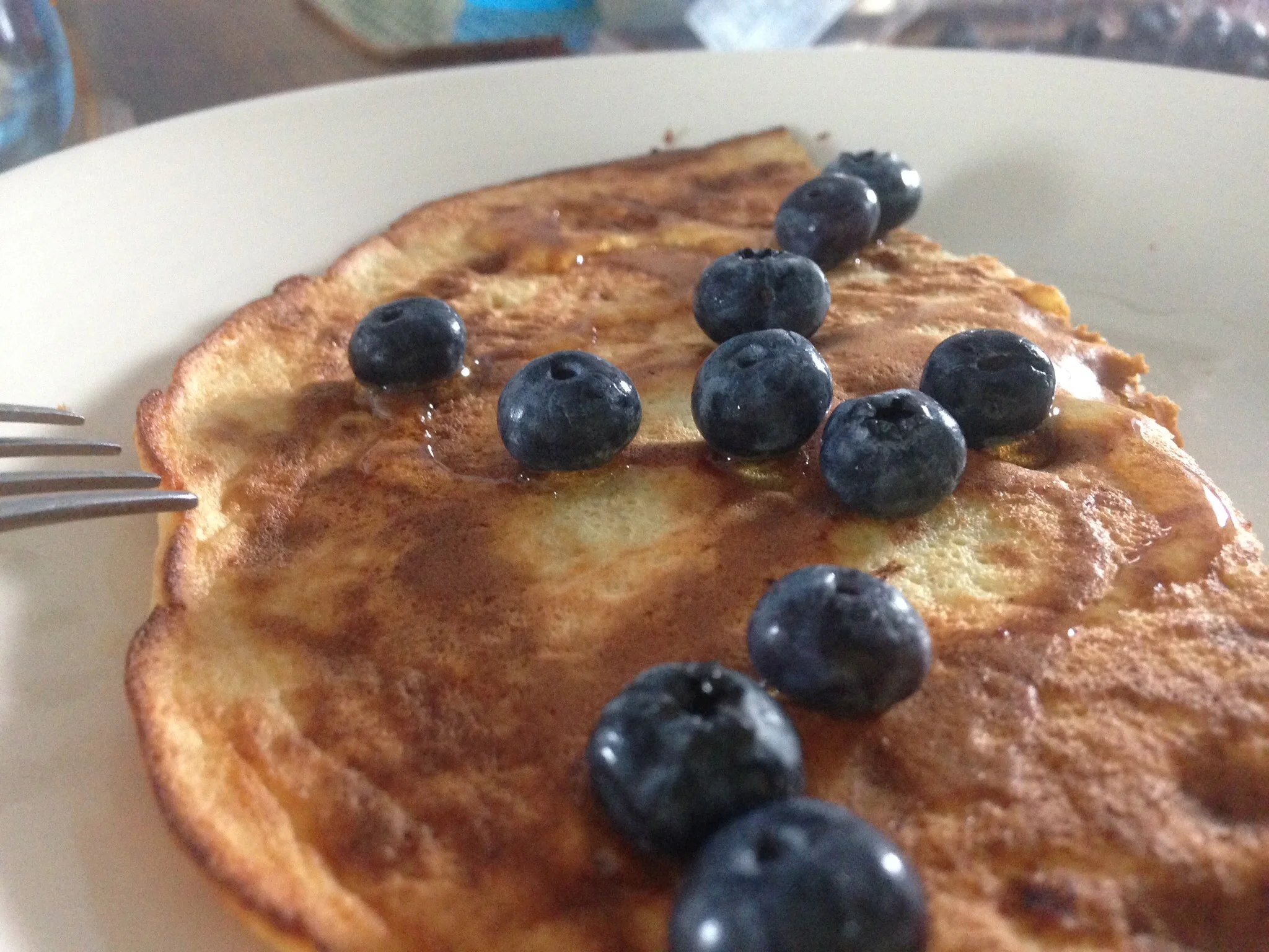 Pancakes served with honey and blueberries.