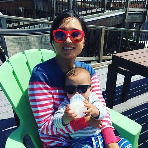 Carolyn is feeding Silas, her nephew, at Canon Beach, Oregon, while on vacation.