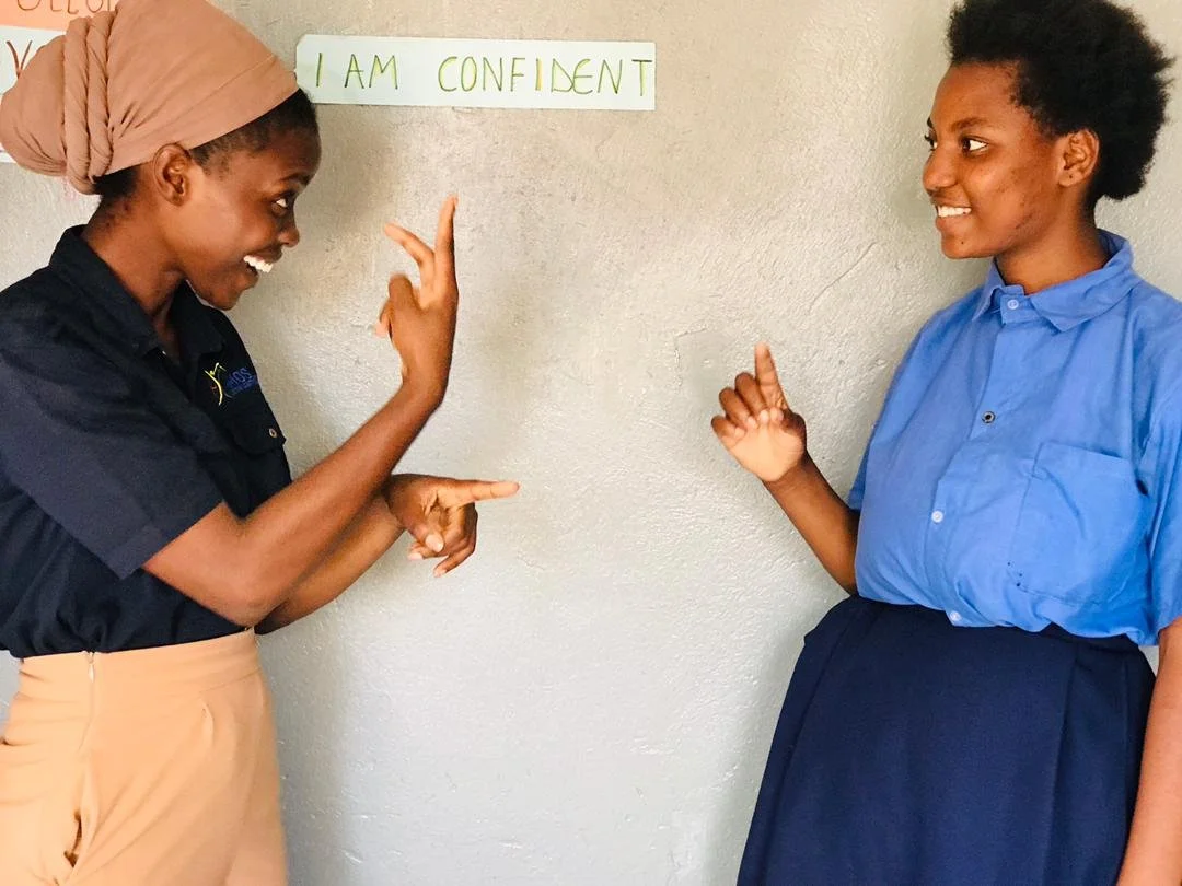 A teacher signs to a student happily.