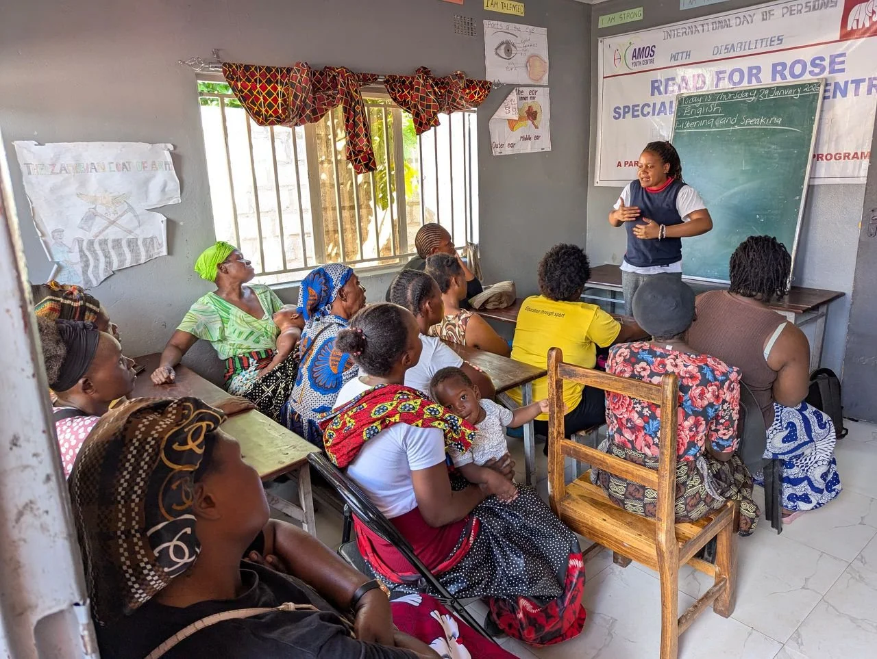 A Zambian teacher, Christine, stands in front of a group of mothers from the Read for Rose Special Education Program
