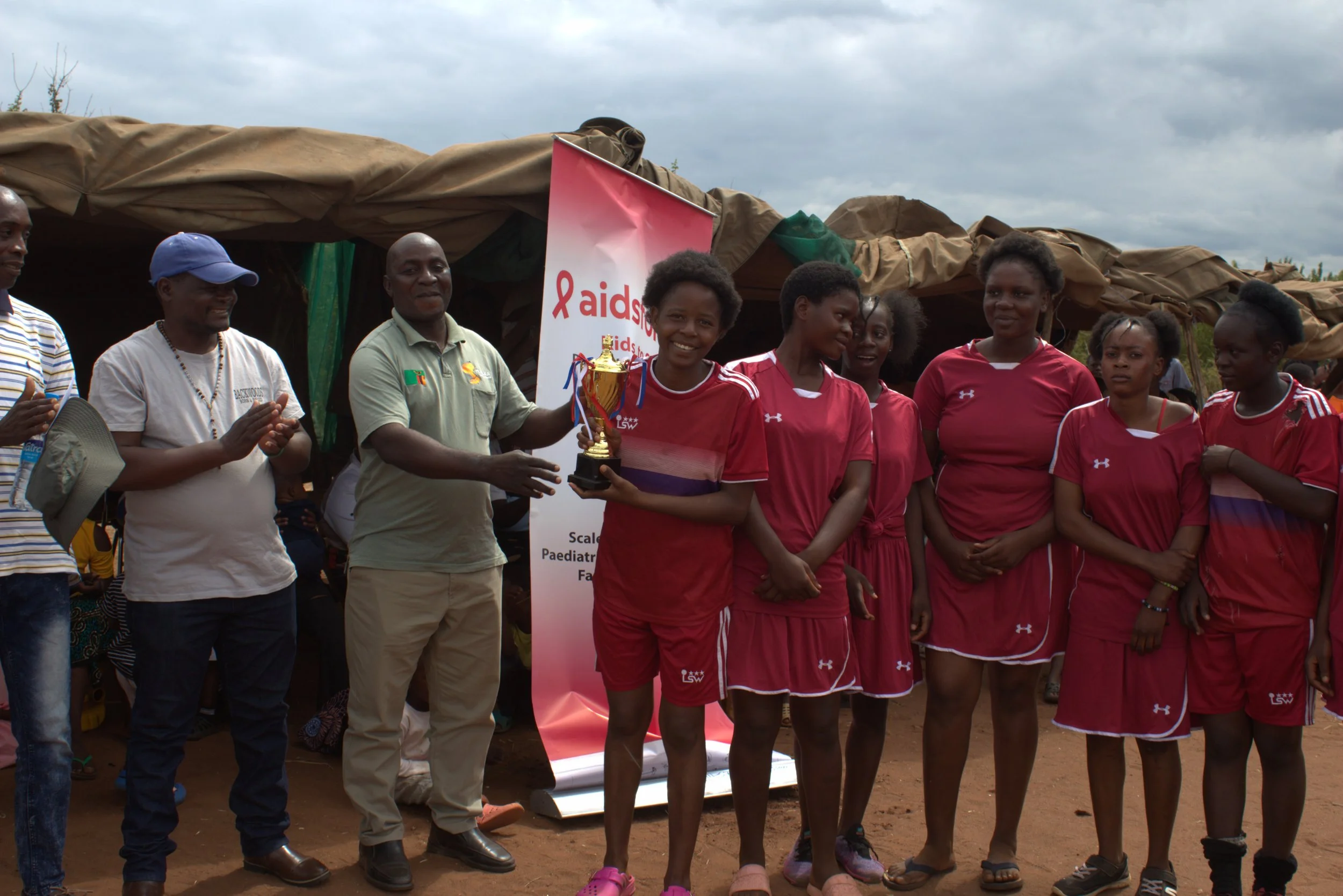 Zambian girls dressed in red sports uniforms are recognized in the Chiawa Chiefdom after a sports tournament.