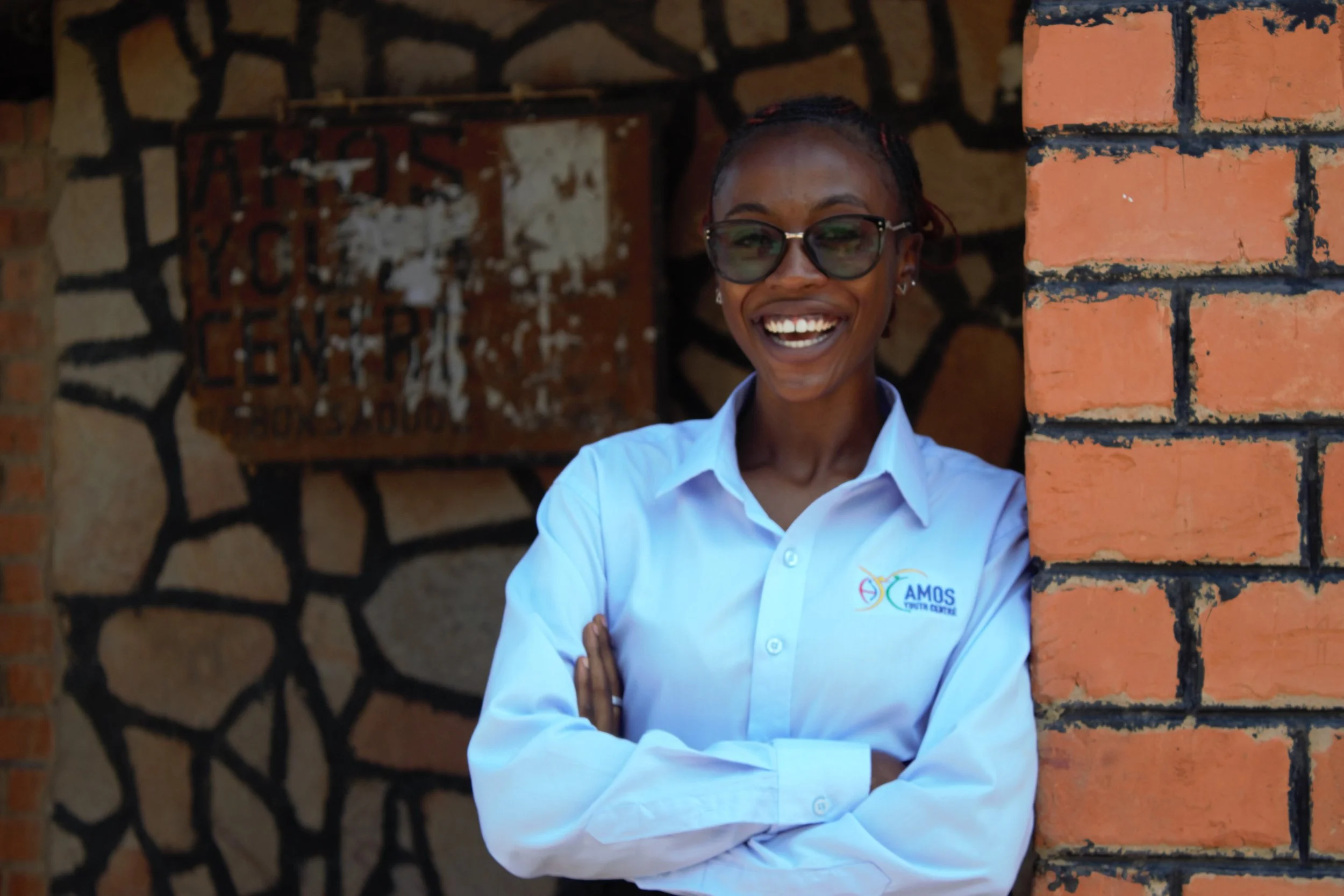 A Zambian girl wearing a blue top smiles for the camera