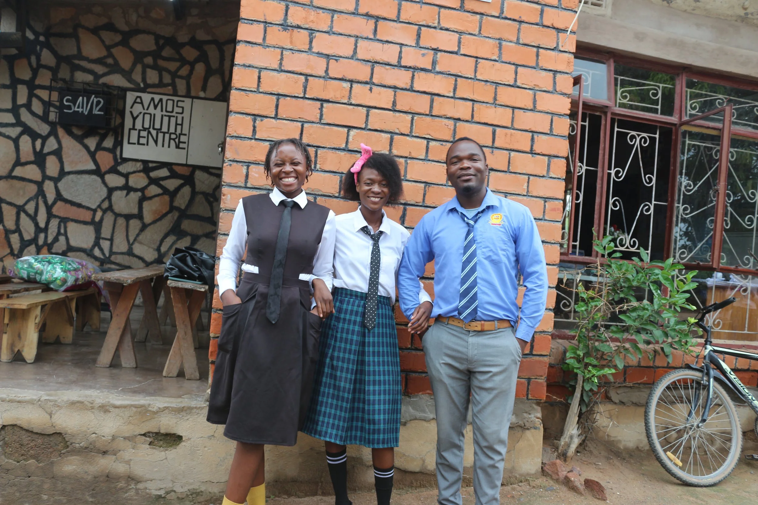 Three Young Learners teachers, two females and one male, pose for the camera.