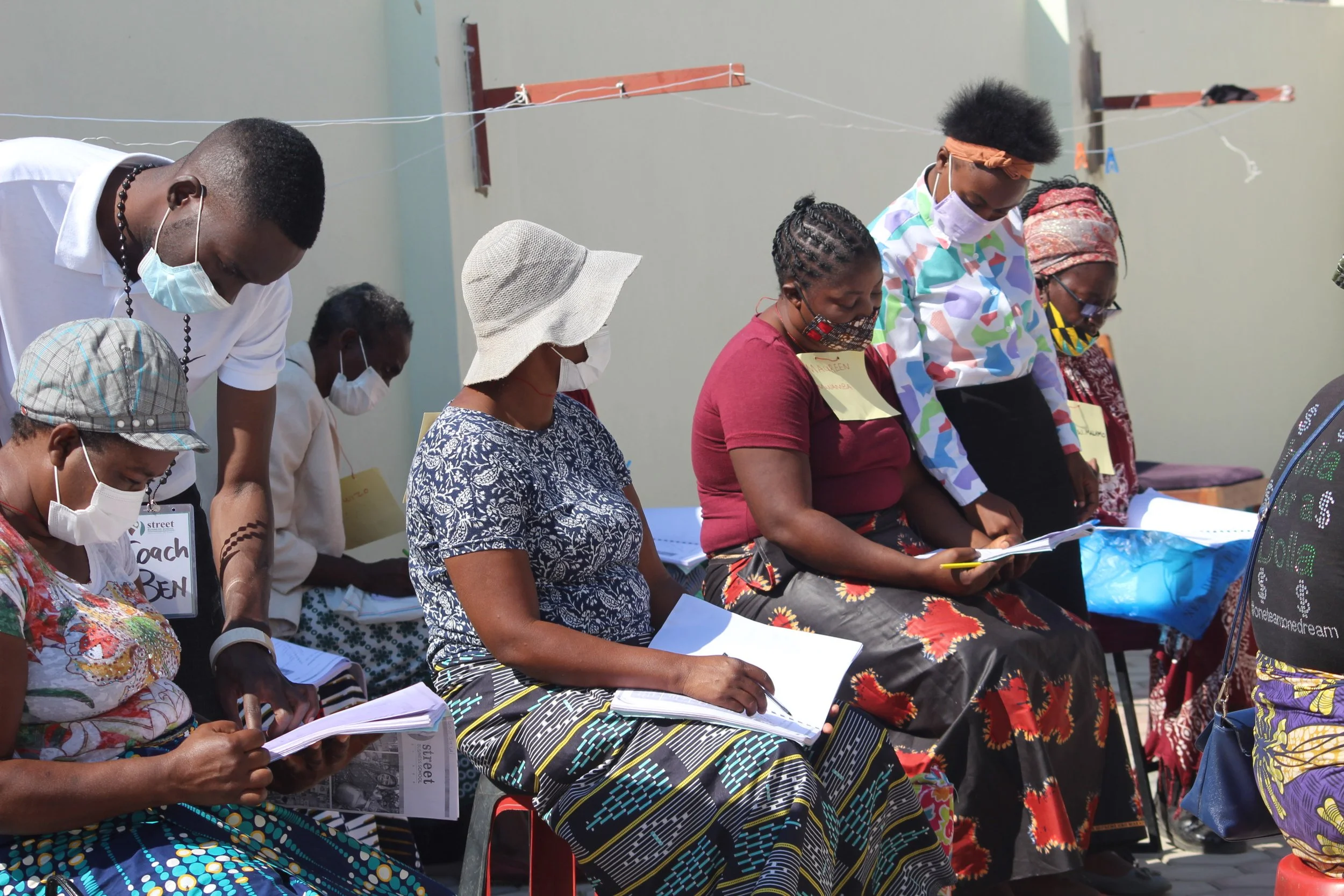 A photo of five Zambian women in an outdoor classroom during the Covid pandemic.
