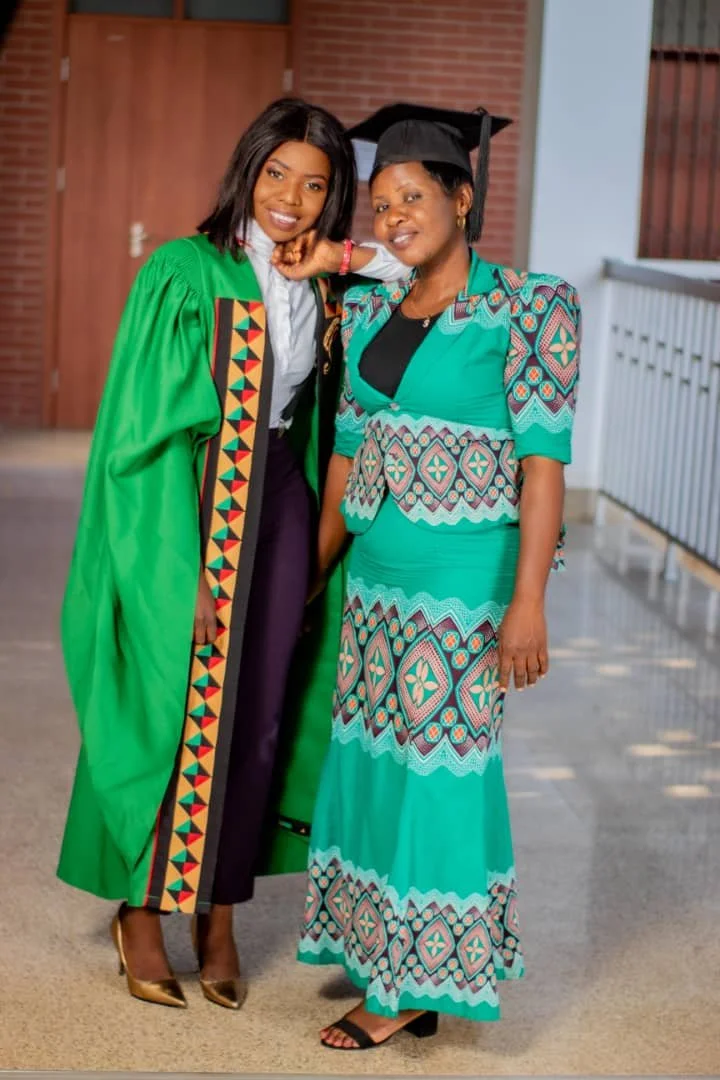 Picture of Angela in her graduation gown standing next to her mother.