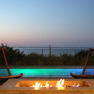 At night, the lap pool lights up, setting the mood for outdoor summer parties while the cement fire pit is perfect for chilly evenings.