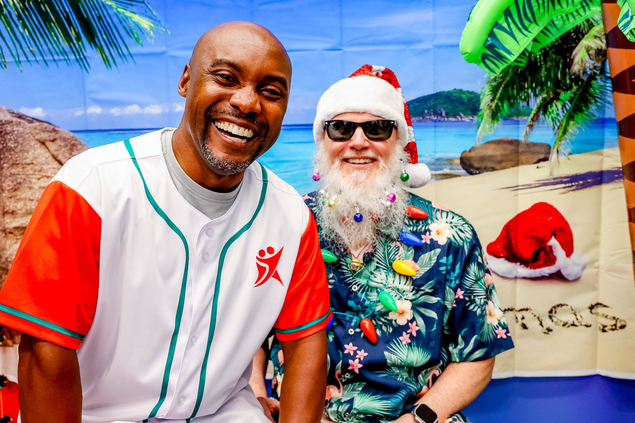 Two attendees smile together at Inspiredu's tropical-themed Xmas in July celebration.