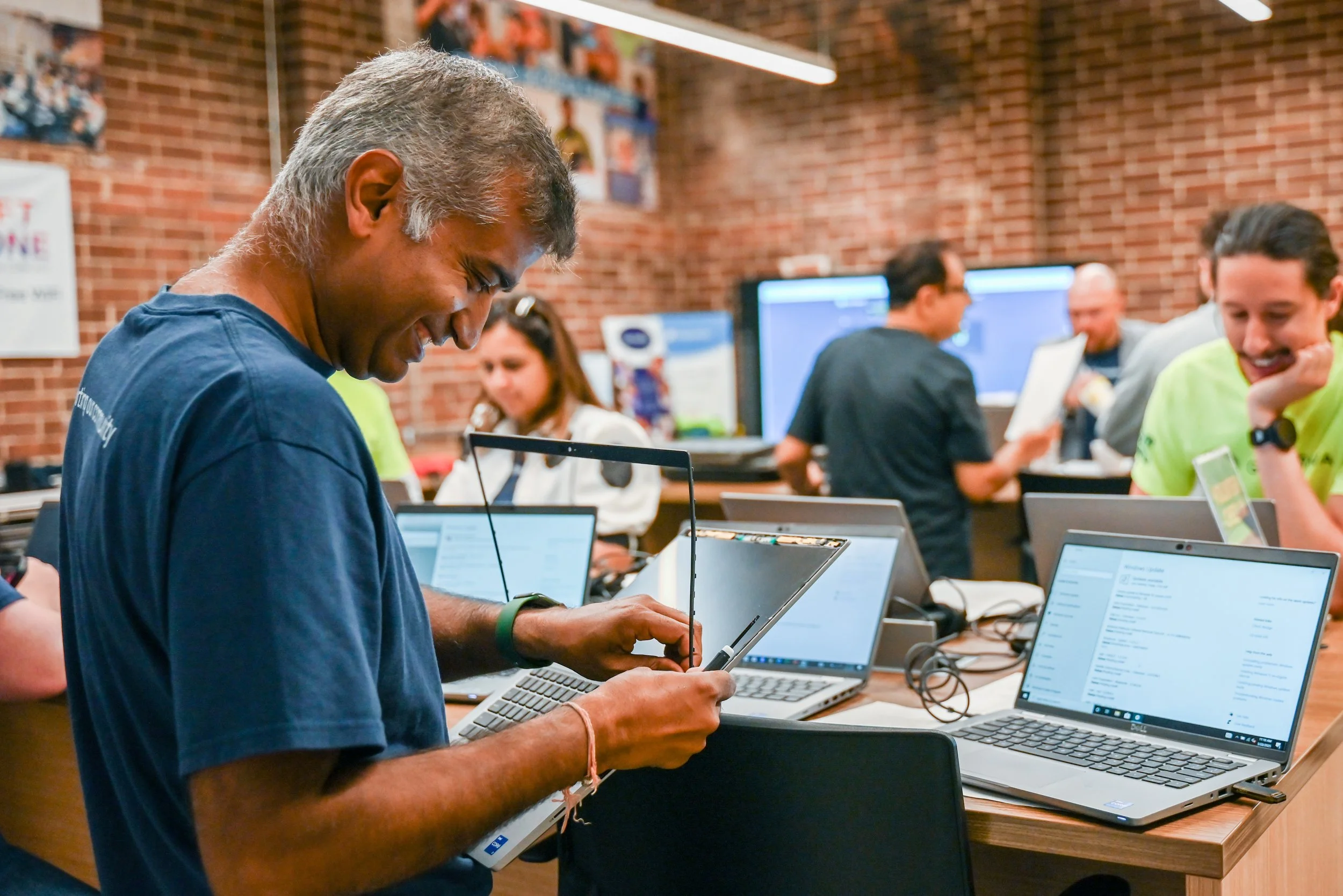 Inspiredu Tech Team volunteer preparing and repairing laptops for community programs.