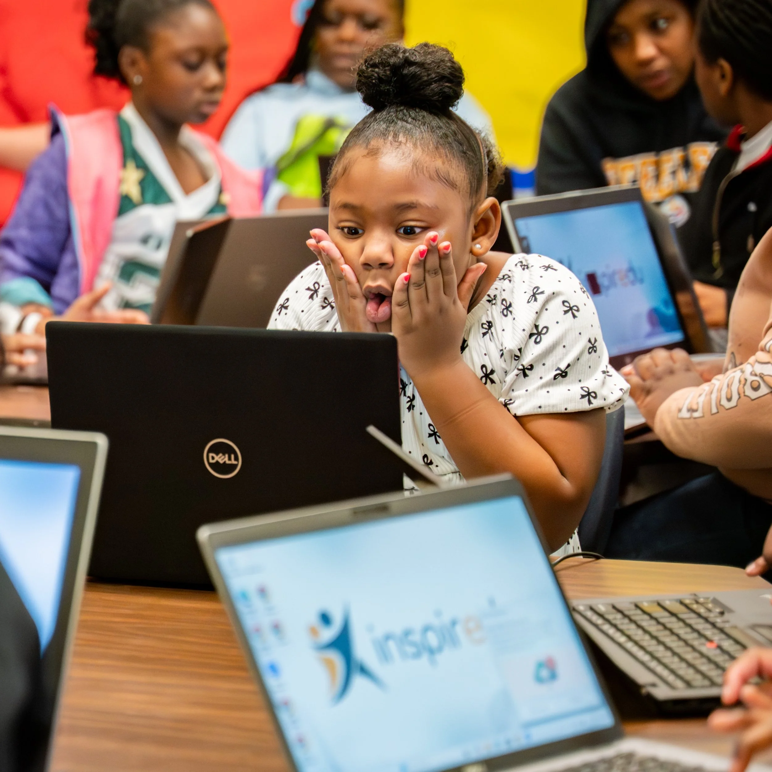 Student reacting excitedly while using a laptop during an Inspiredu digital learning activity.