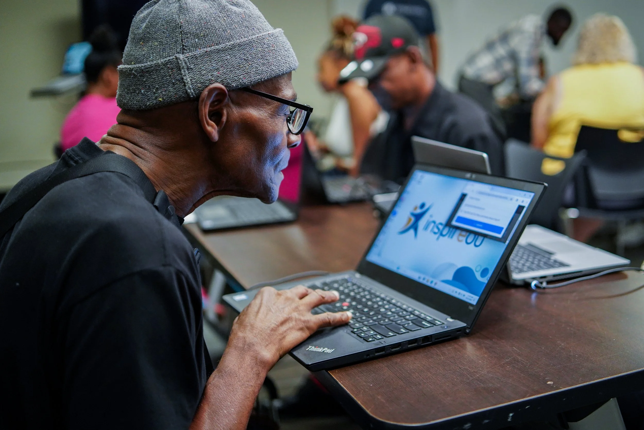 Adult learner using a laptop during an Inspiredu digital literacy workshop.