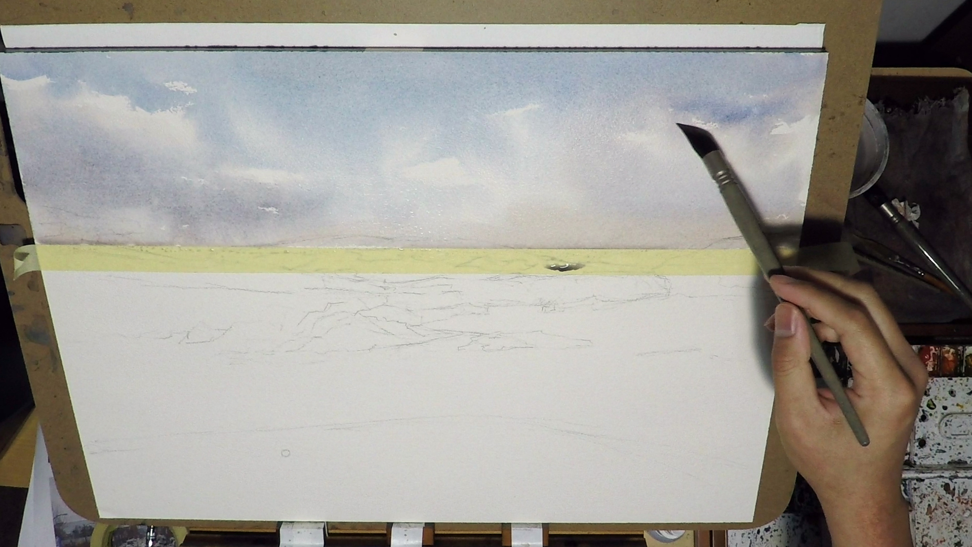 3. I started to give the cloud some volume by adding some dark. Use the same color with your sky but add some other paint such as Alizarin Crimson and a touch of Burnt Umber. I re-wet the area as needed, and I soften some edges with clean waters. I turn the paper side ways sometime so the wash won't carry all the paint vertically.