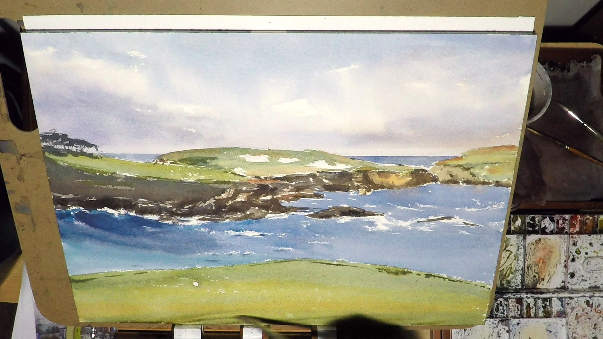 1. I added some trees in the background rock. It's just a very simple shape so I don't fuss with it too much. I then started to paint the foreground green. Again I kept it as clean as possible. I painted around the golf ball. My usual green mixture …