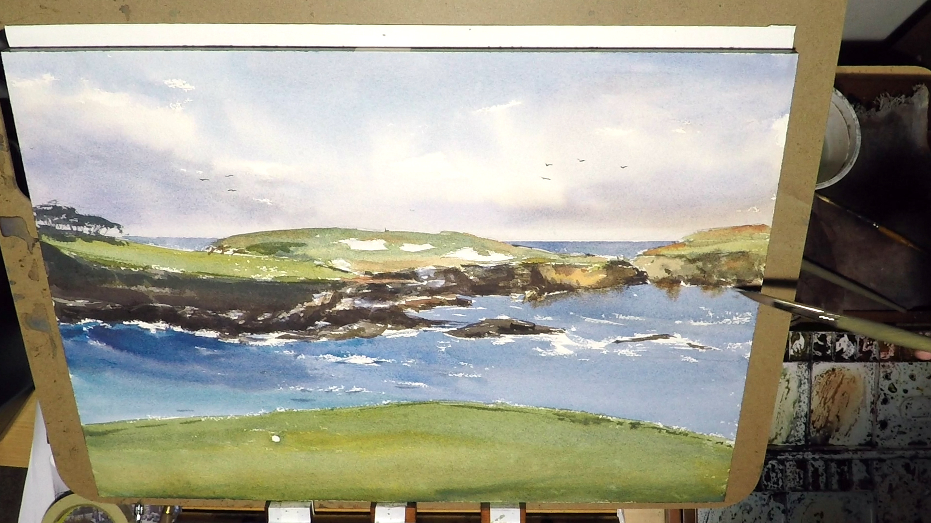 2. I did a glaze for the foreground green after it's dry. Making it a bit darker will separate it from the mid and background. This is where the viewer is standing, so it should feel solid. It's also the time to added some seagulls in the background sky and some final touches here and there.