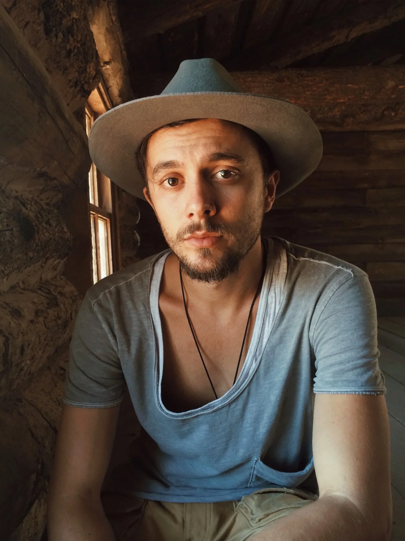  Joe Greer, photographer, sits in a gray shirt and hat. Photo by Paul Tellefsen 