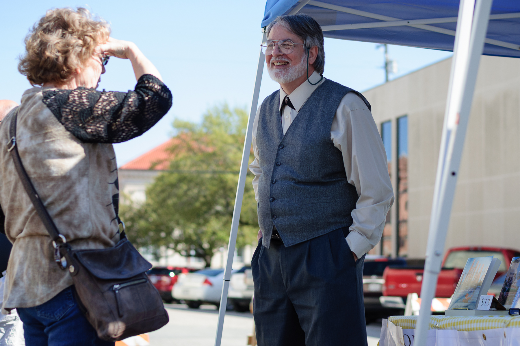 Author John Moody actively interacting with visitors to his booth where he was promoting and selling his novels. He was one of the many writers that were present at the festival.