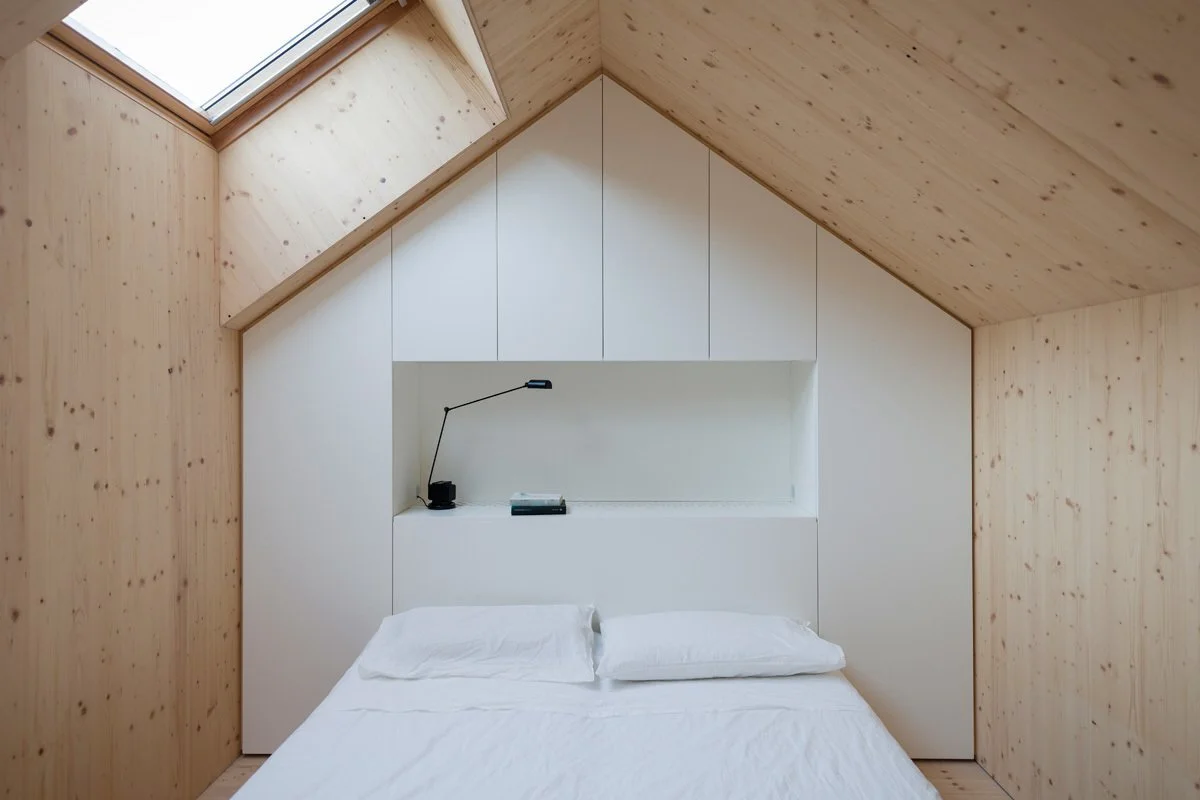 pitched-roof-bedroom-with-skylight-and-wood-walls.jpg