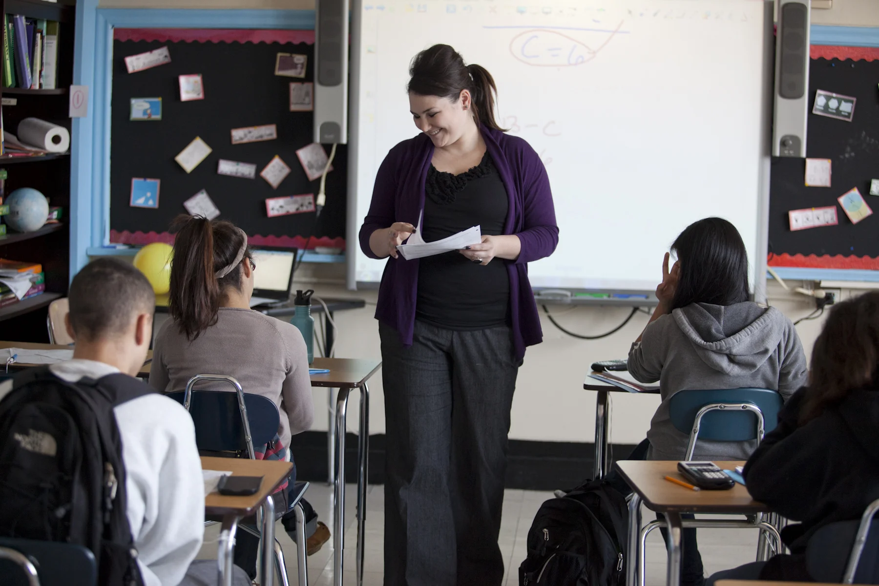 Teacher Sarah Prendergast hands out mastery checks to her students.