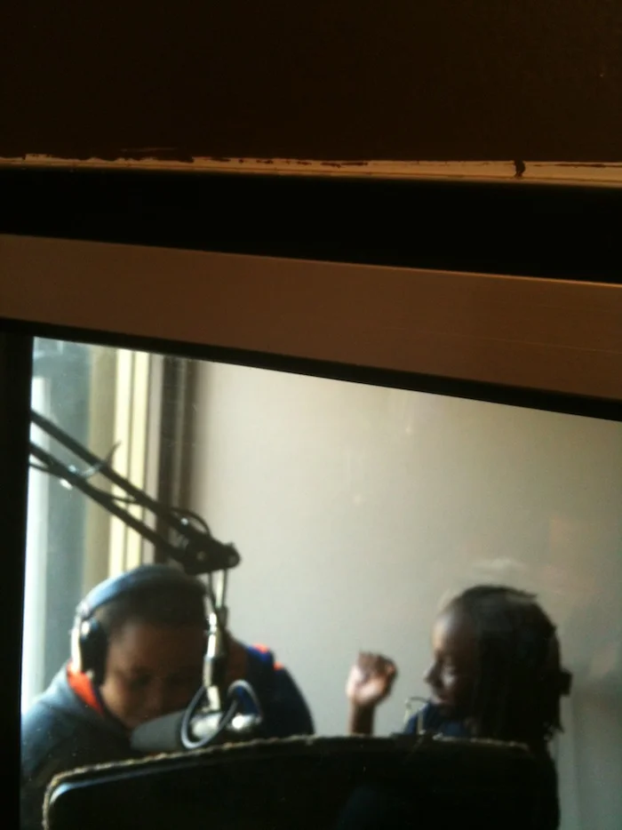 Students doing voice-over work in the sound booth during "The World of Sound Recording" session.