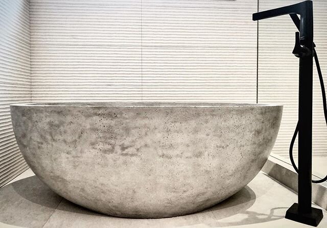 Stunning concrete soaker tub, surrounded by beautiful linear, chalky tiles and oversized floor tiles both by @porcelanosacalgary All masterfully installed by @squaretiles.ca .
.
*all images on this page are designed by @russellandrusselldesignstudios