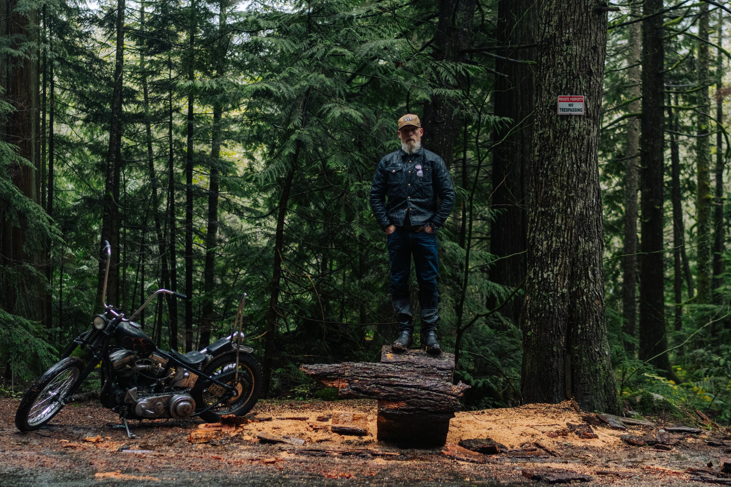 Embracing the elements in style! 🌲🏍️ This rugged adventurer conquers the Pacific Northwest rainforest on his sleek motorcycle, donned in the epitome of cool—the Black Bear Brand wax canvas jacket.