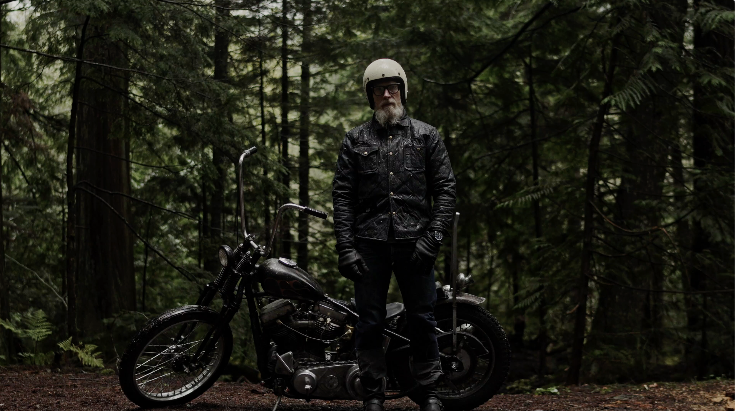 Embracing the elements in style! 🌲🏍️ This rugged adventurer conquers the Pacific Northwest rainforest on his sleek motorcycle, donned in the epitome of cool—the Black Bear Brand wax canvas jacket.