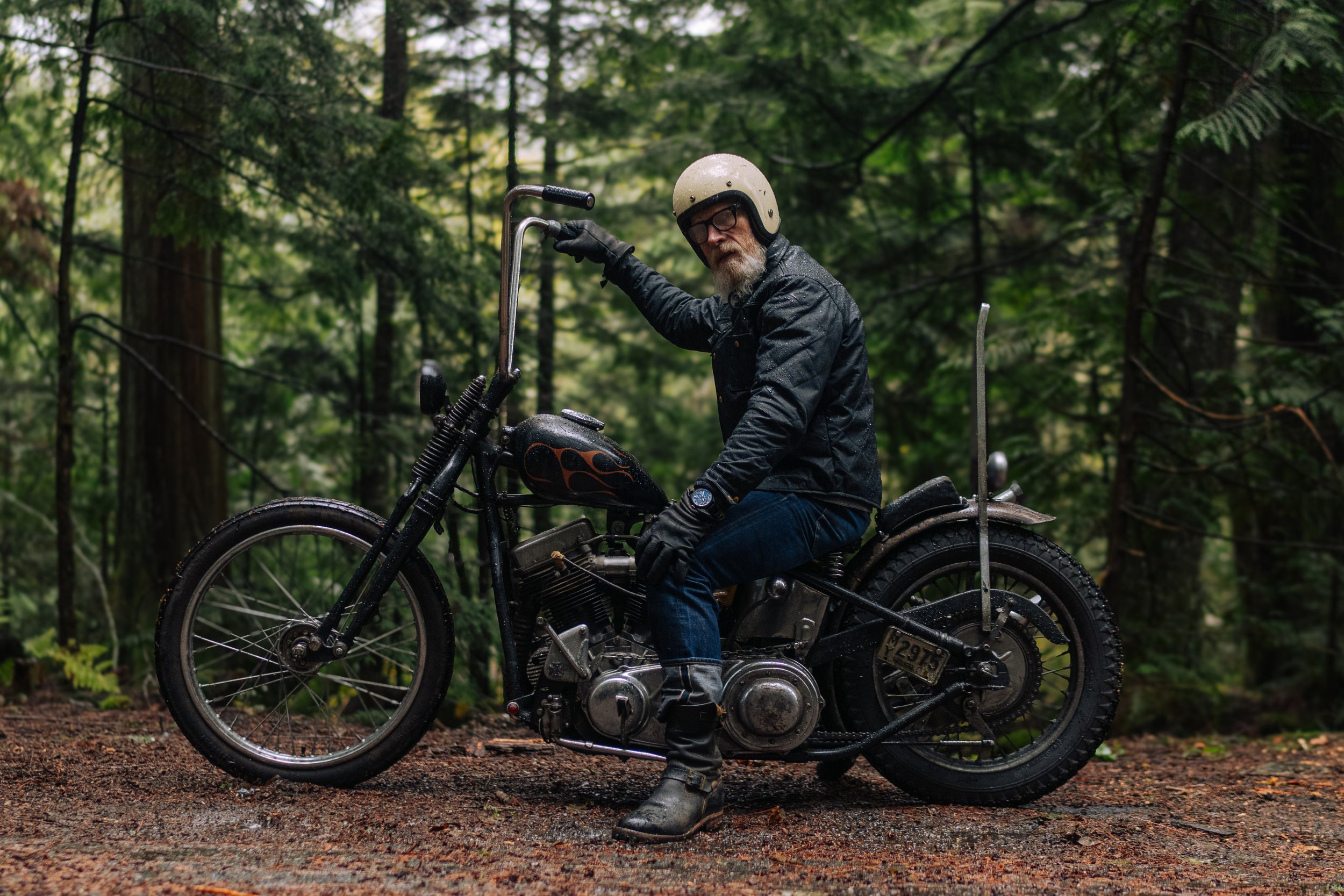 Embracing the elements in style! 🌲🏍️ This rugged adventurer conquers the Pacific Northwest rainforest on his sleek motorcycle, donned in the epitome of cool—the Black Bear Brand wax canvas jacket.