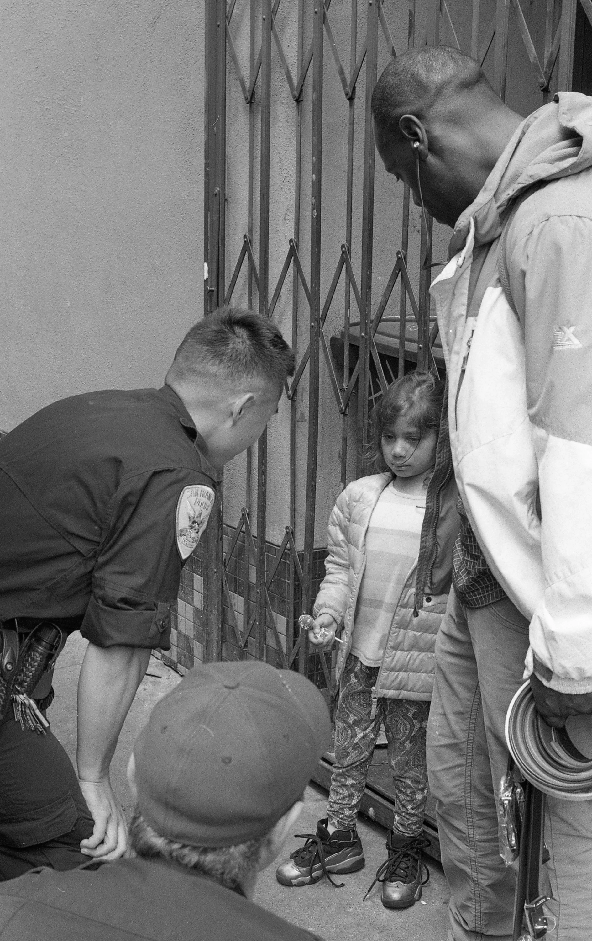 Officer Kevin Fong attends to lost child on a corner in the Tenderloin district known for active drug dealing. Officer Fong, who was being helped by members of the community, found the child’s mother in a laundry mat down the street.