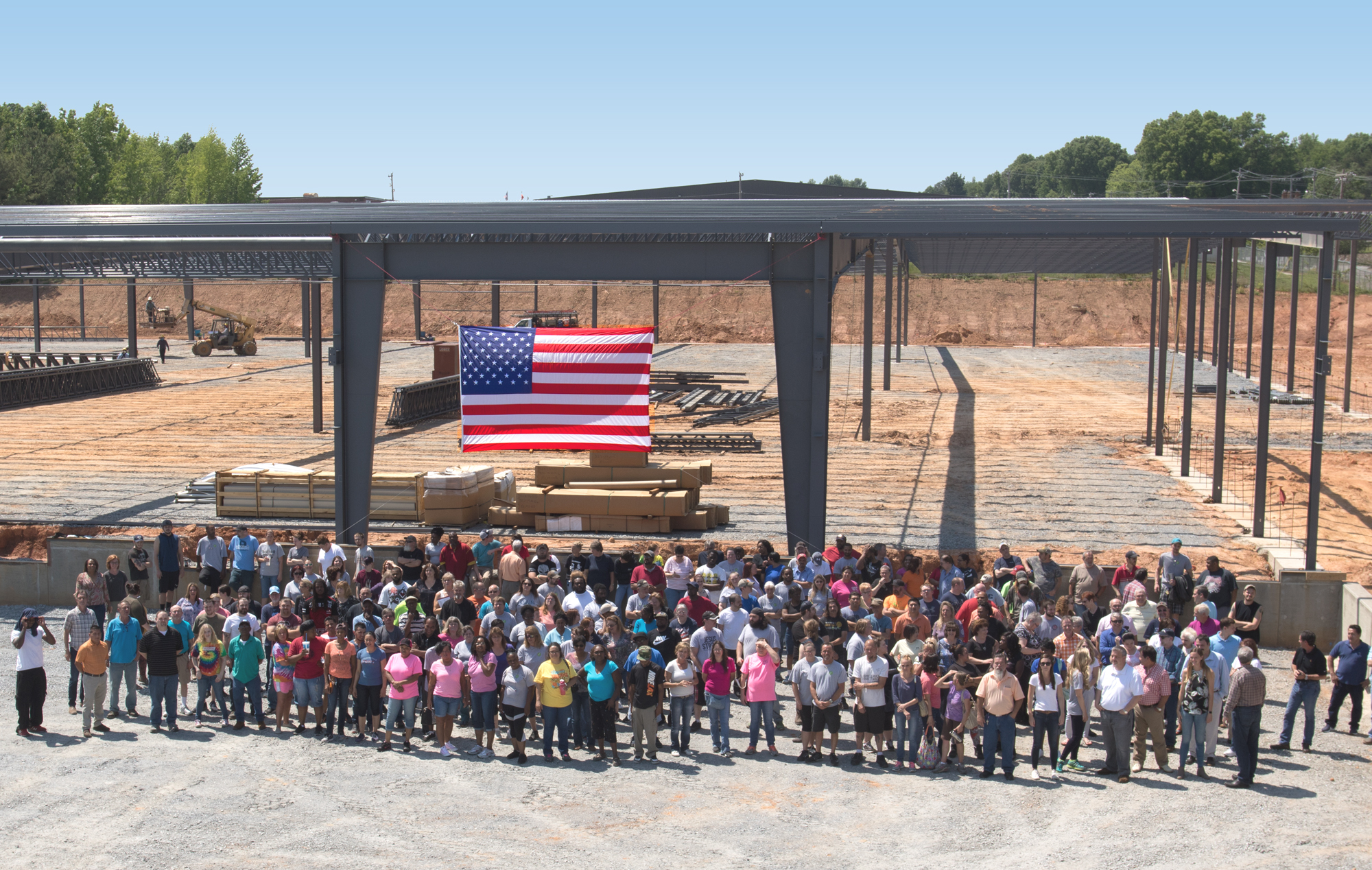 Above: A group of STI employees standing in front of their new 150,000 sq. ft. plant that opened in January 2018.