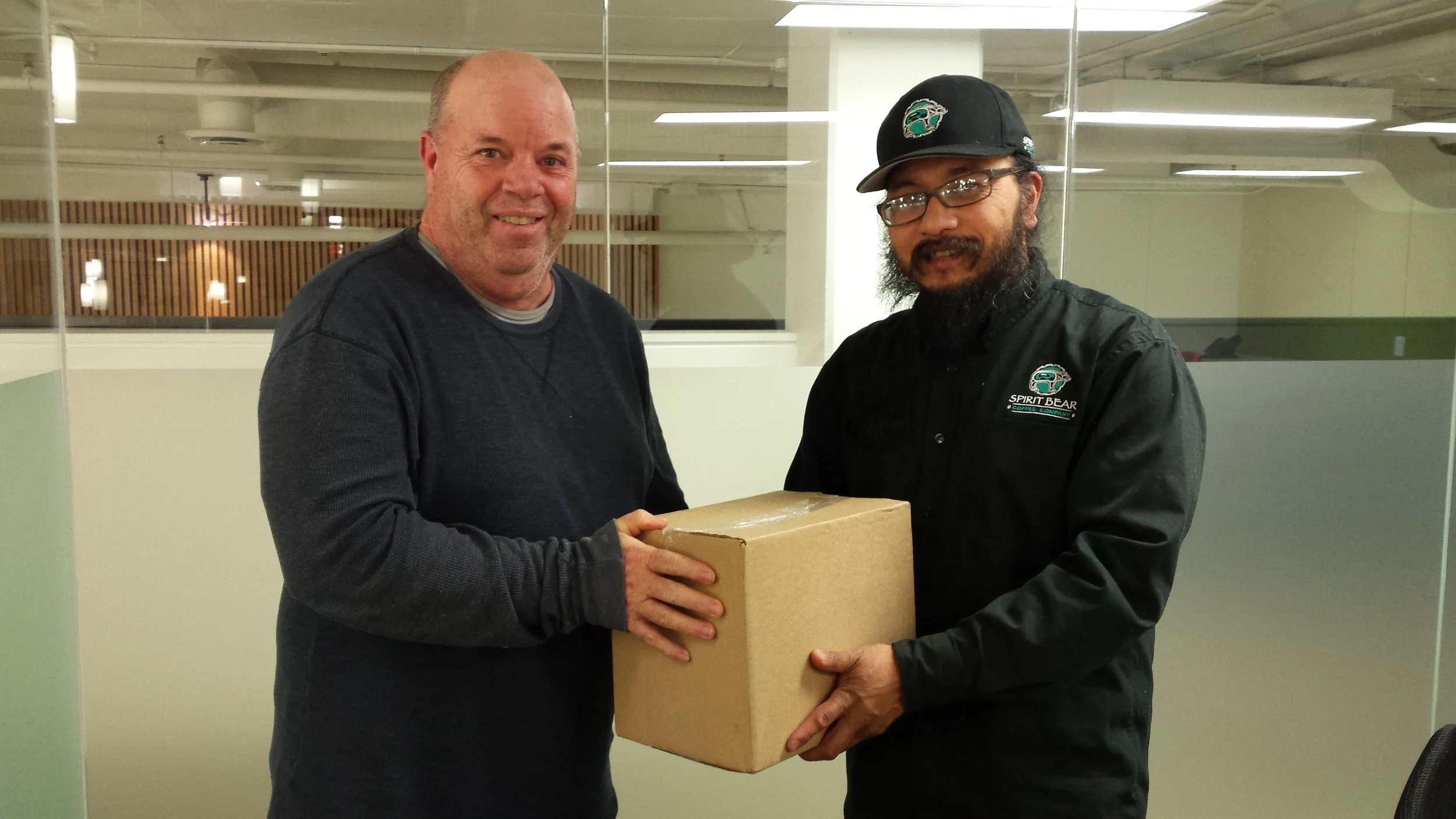 Stewart Brotchie receives a box of Spirit Bear coffee from Jay Peachy after a presentation by Jay at our recent meeting