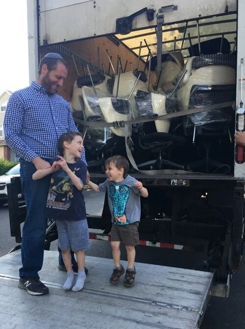 Joshua shown here, teaching some new movers how to load a truck with used Knoll Saarinen office chairs.