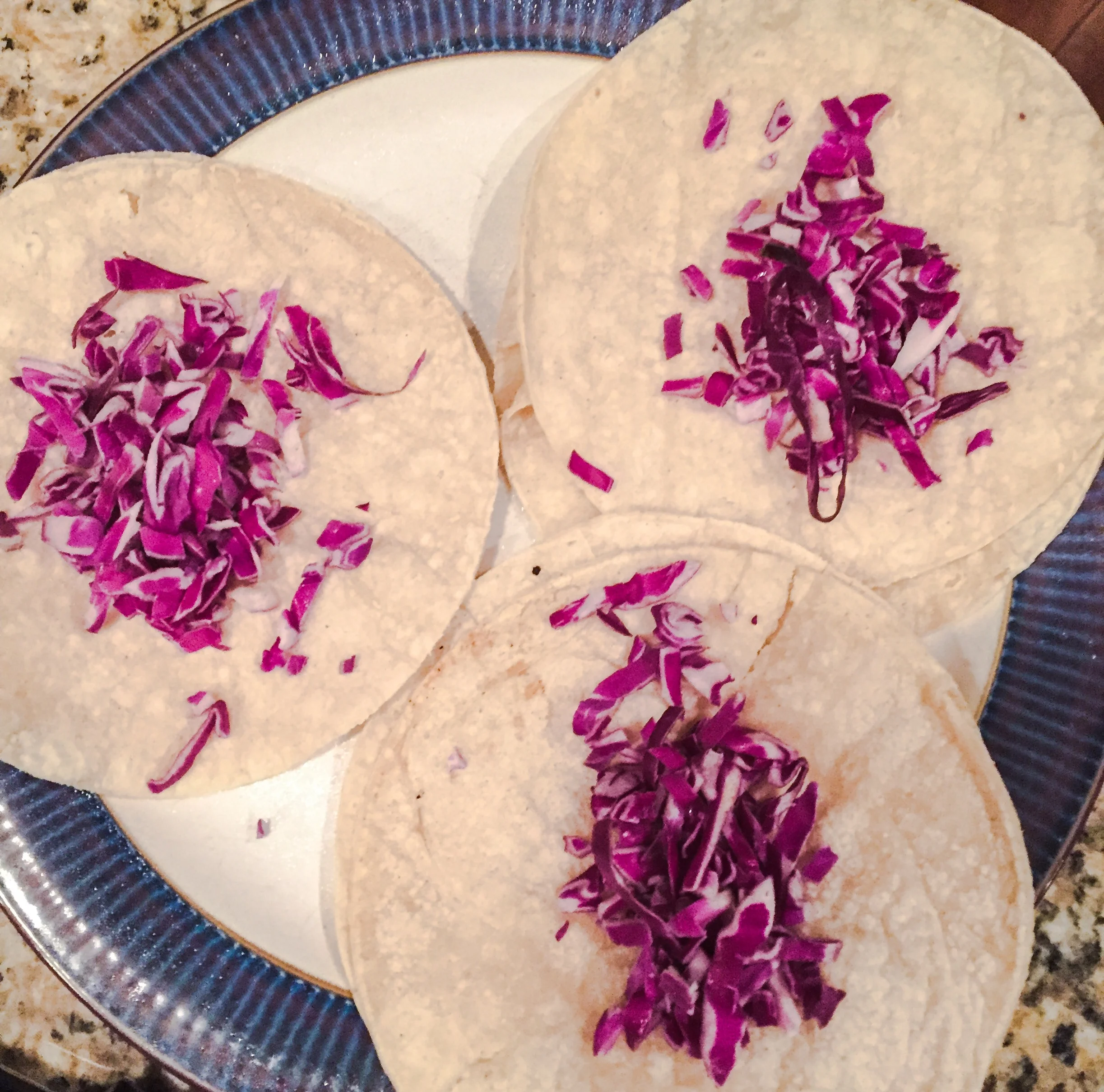 Line up your tacos and sprinkle the cabbage. 