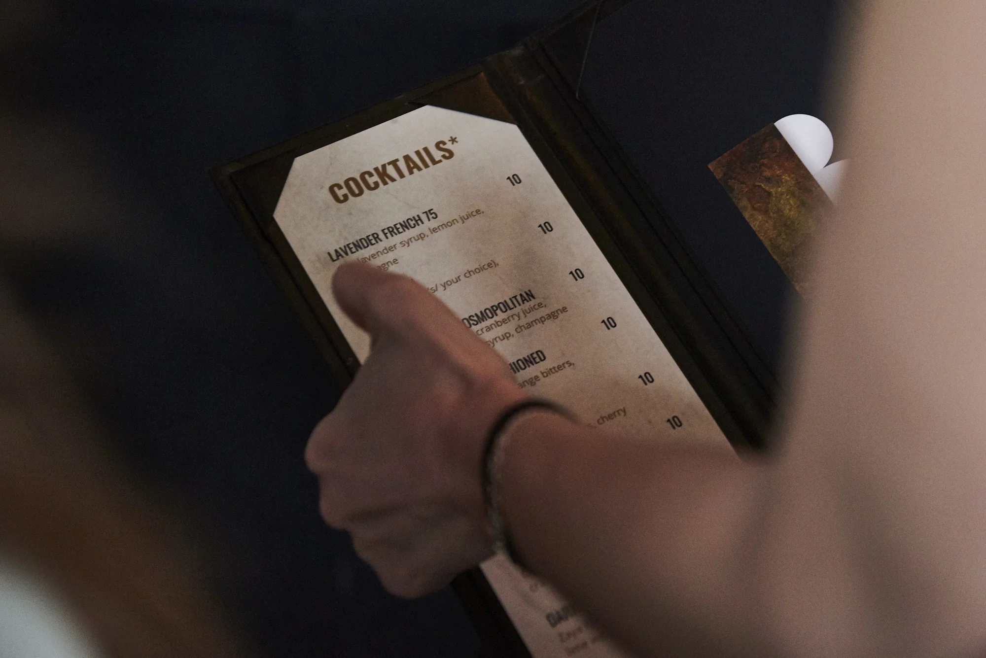 A person holding the cocktail menu