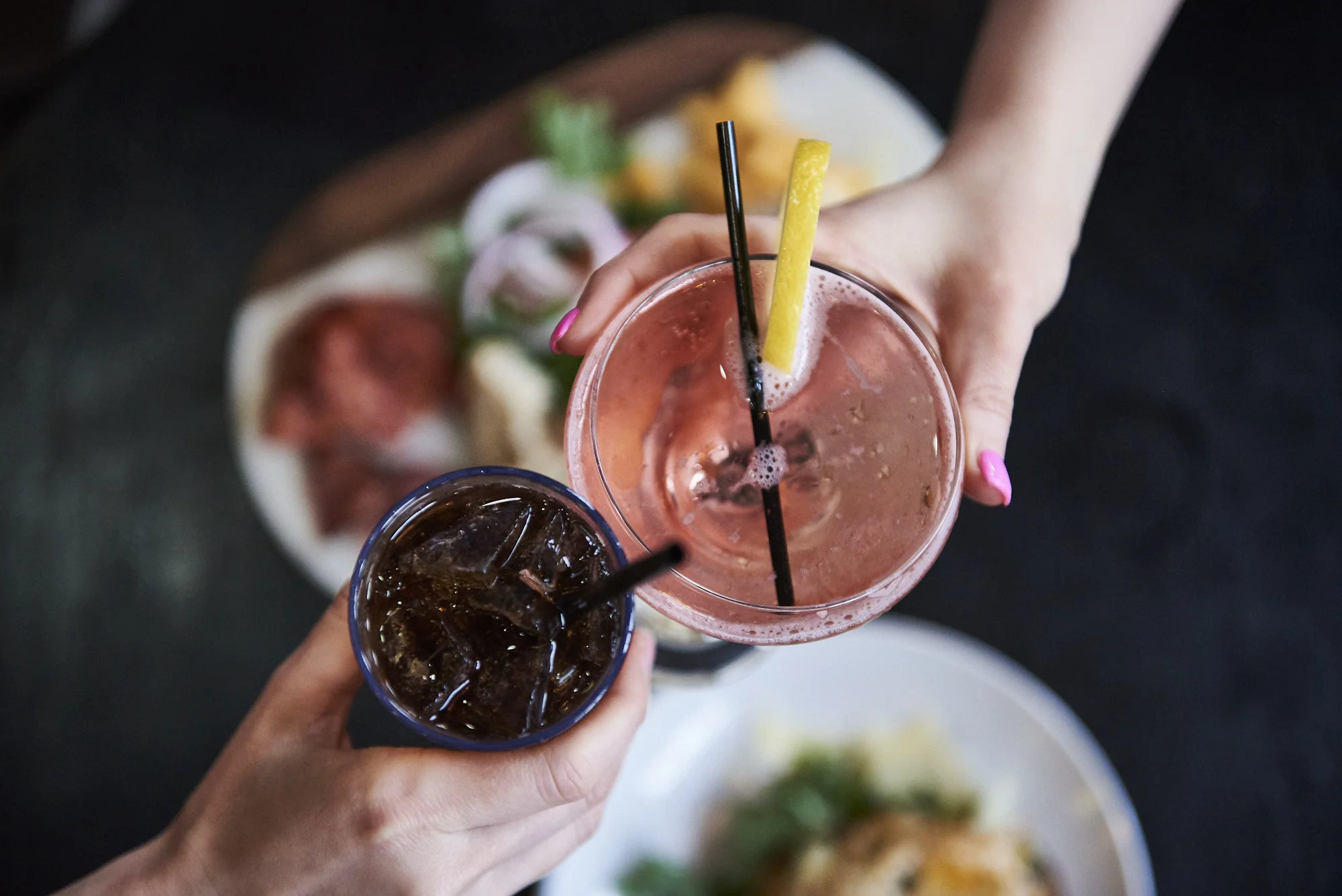 Two hands holding two different drinks