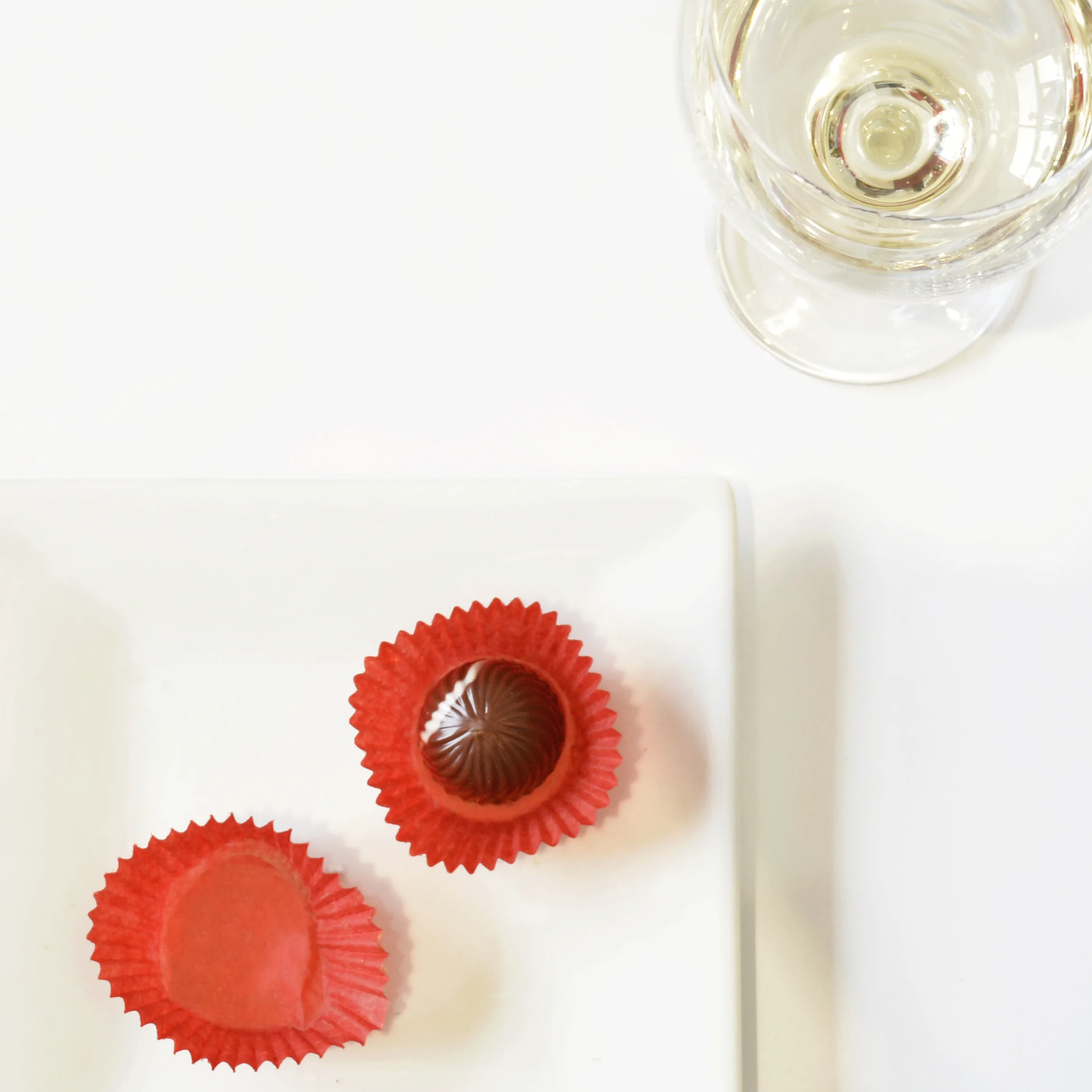 SPRING 2016 - wine and bonbon pairing during my first few months at chuao, i was invite to join in on a wine and bonbon pairing to take some photos. this was one of my first photos taken at chuao. i love the use of white space and how your eye gets drawn right to the bonbon.
