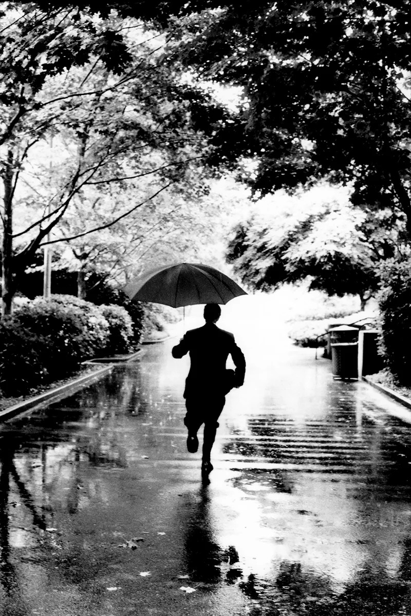Groom runs in the rain to get the rings at the University of Washington in Seattle, WA