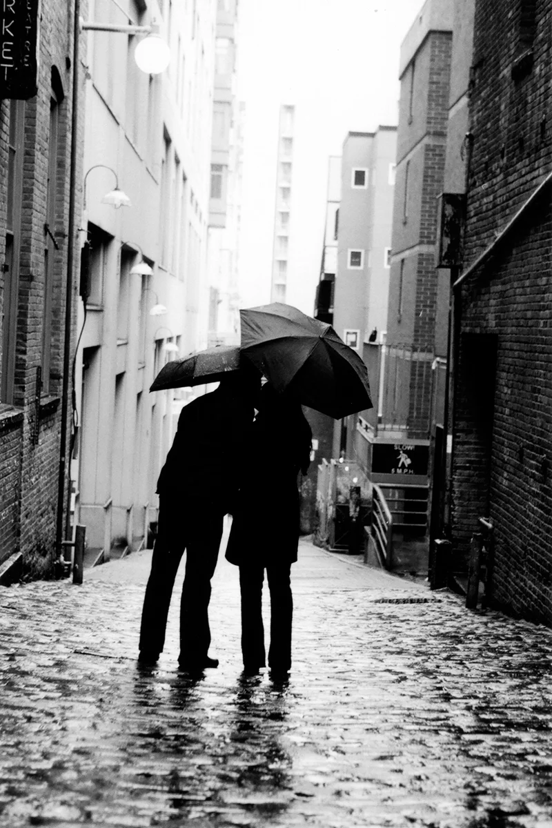 Engagement portrait at Post Alley in Seattle, WA during a rare summer rain