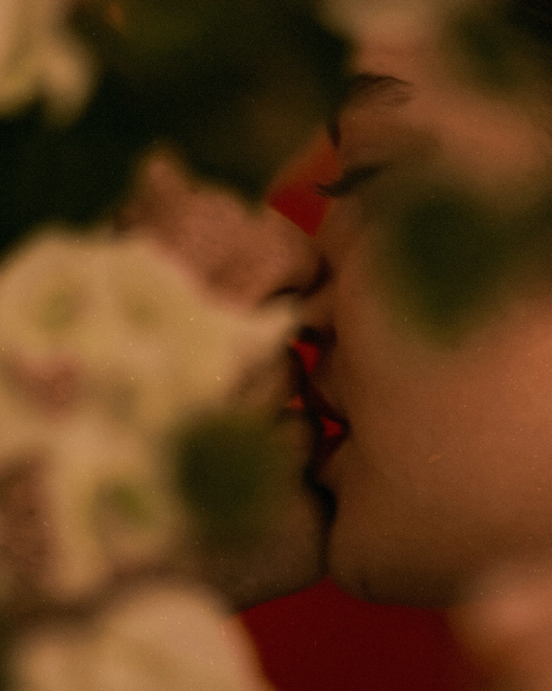 Close-up of two people kissing, with their faces close together and eyes closed.
