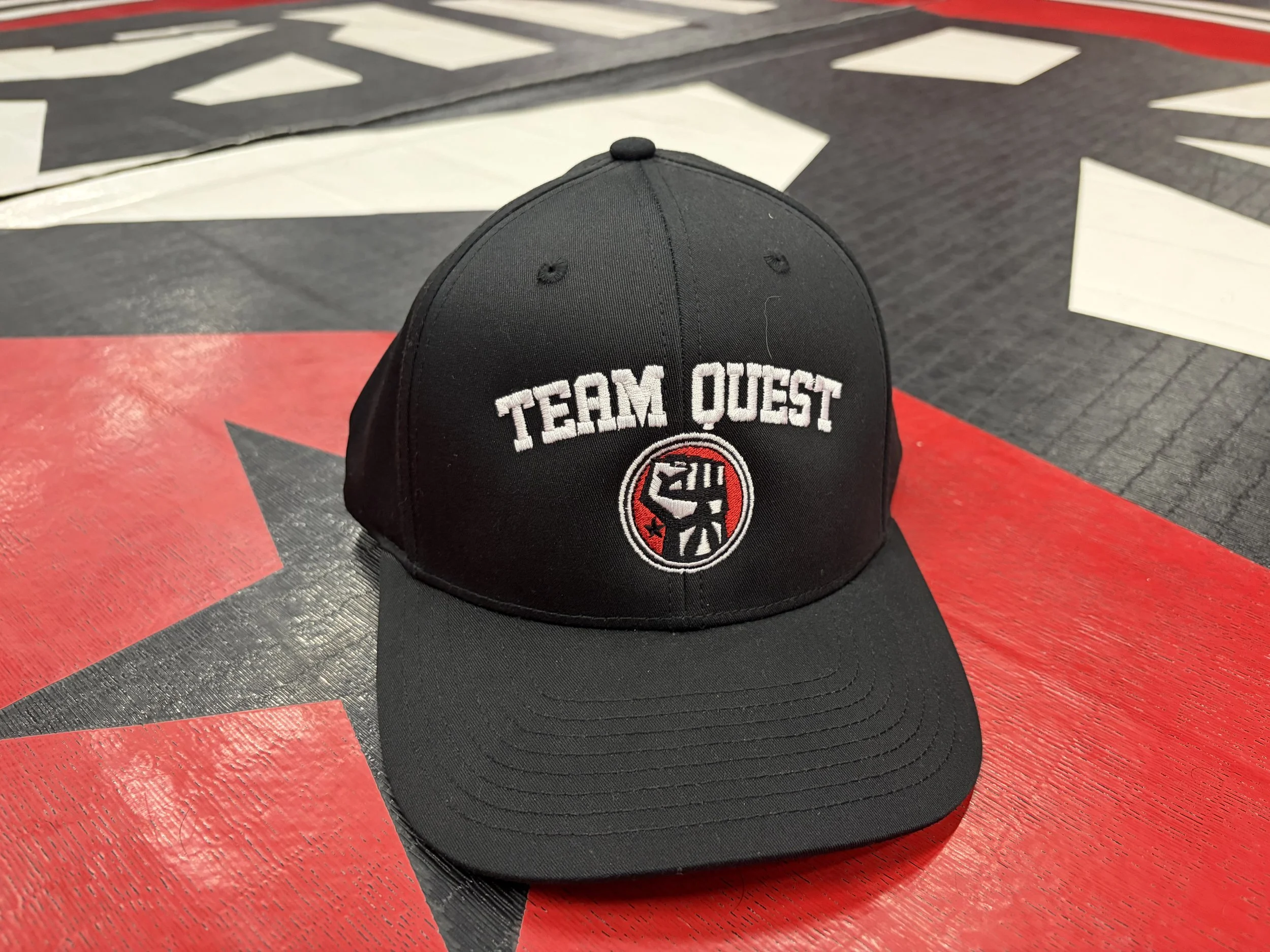 Circle Fist Logo Team Quest Baseball Hat