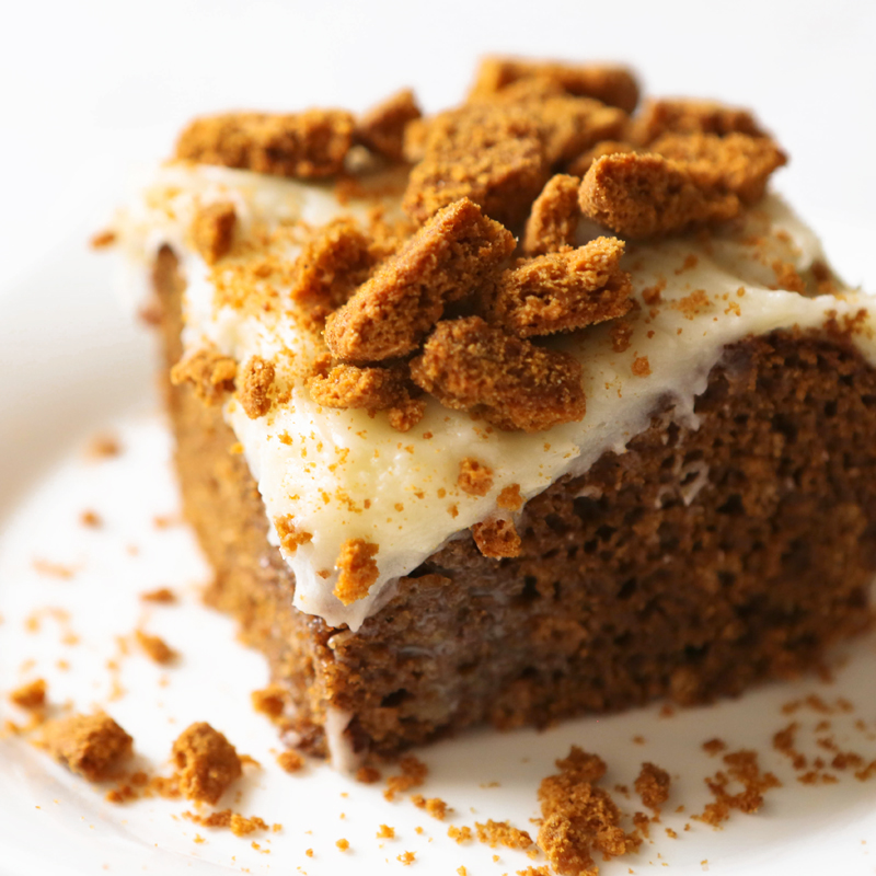 close up piece of cake with drippy frosting and cookies on top