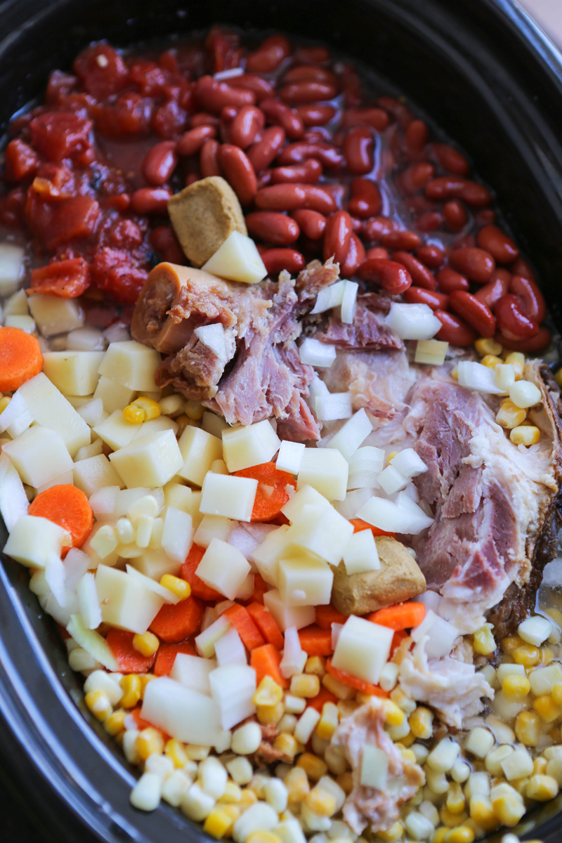 Crock pot filled with ham bone soup ingredients ready to cook