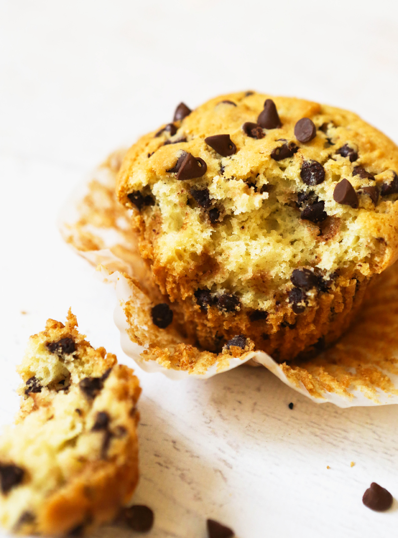 a bite taken out of a muffin sitting on a cupcake liner