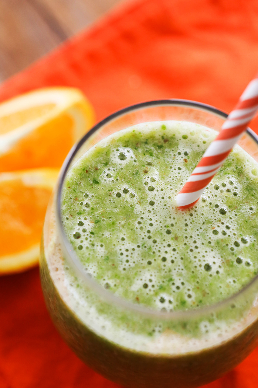 Close up of a orange banana smoothie with a paper straw in it