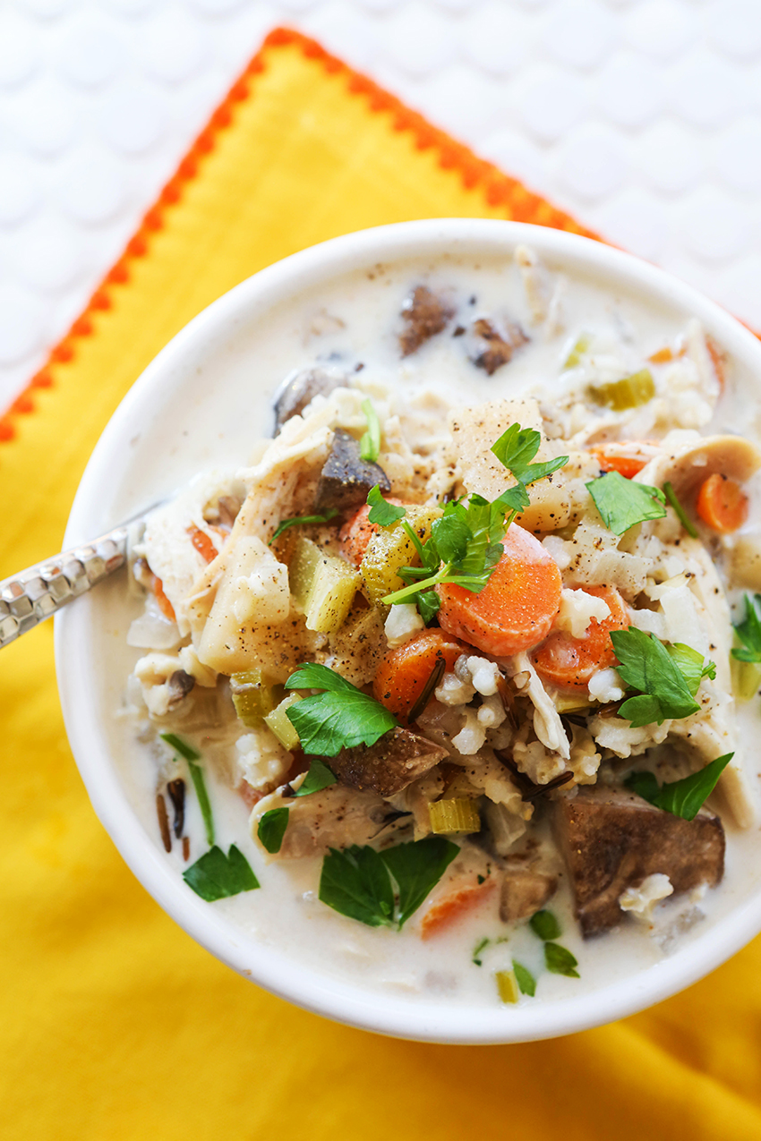 top view of bowl of crockpot chicken wild rice soup on a yellow place mat