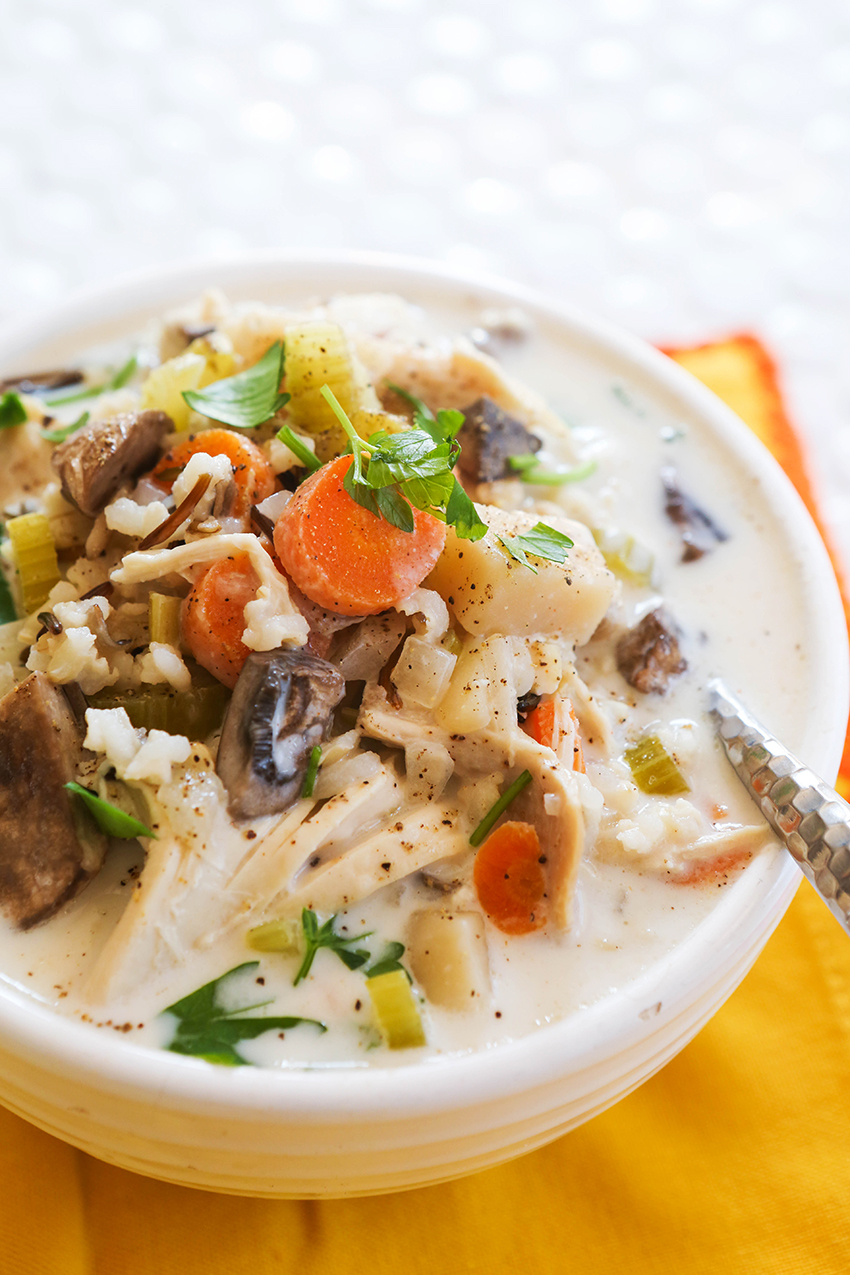 bowl of chicken soup piled high with veggies and chicken and rice