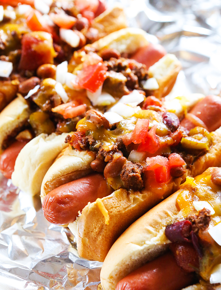A lineup of perfectly cooked chili dogs.