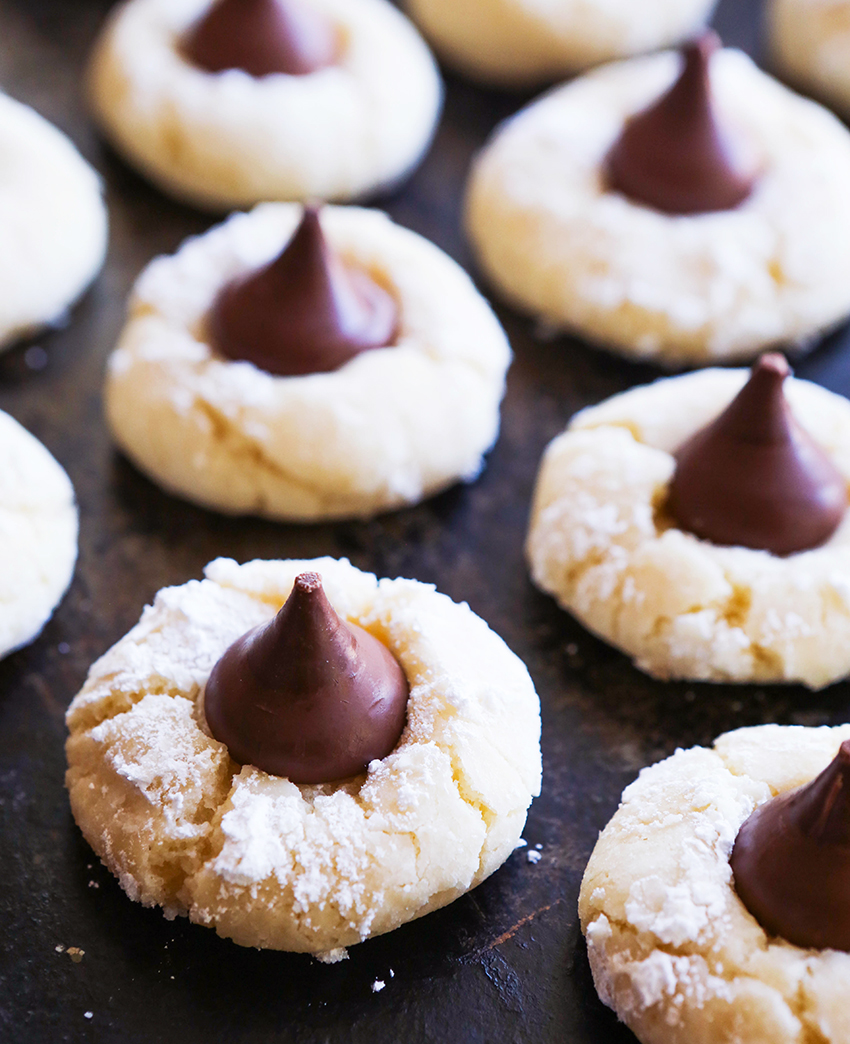 cream cheese cookies on baking sheet with chocolate kisses in centers