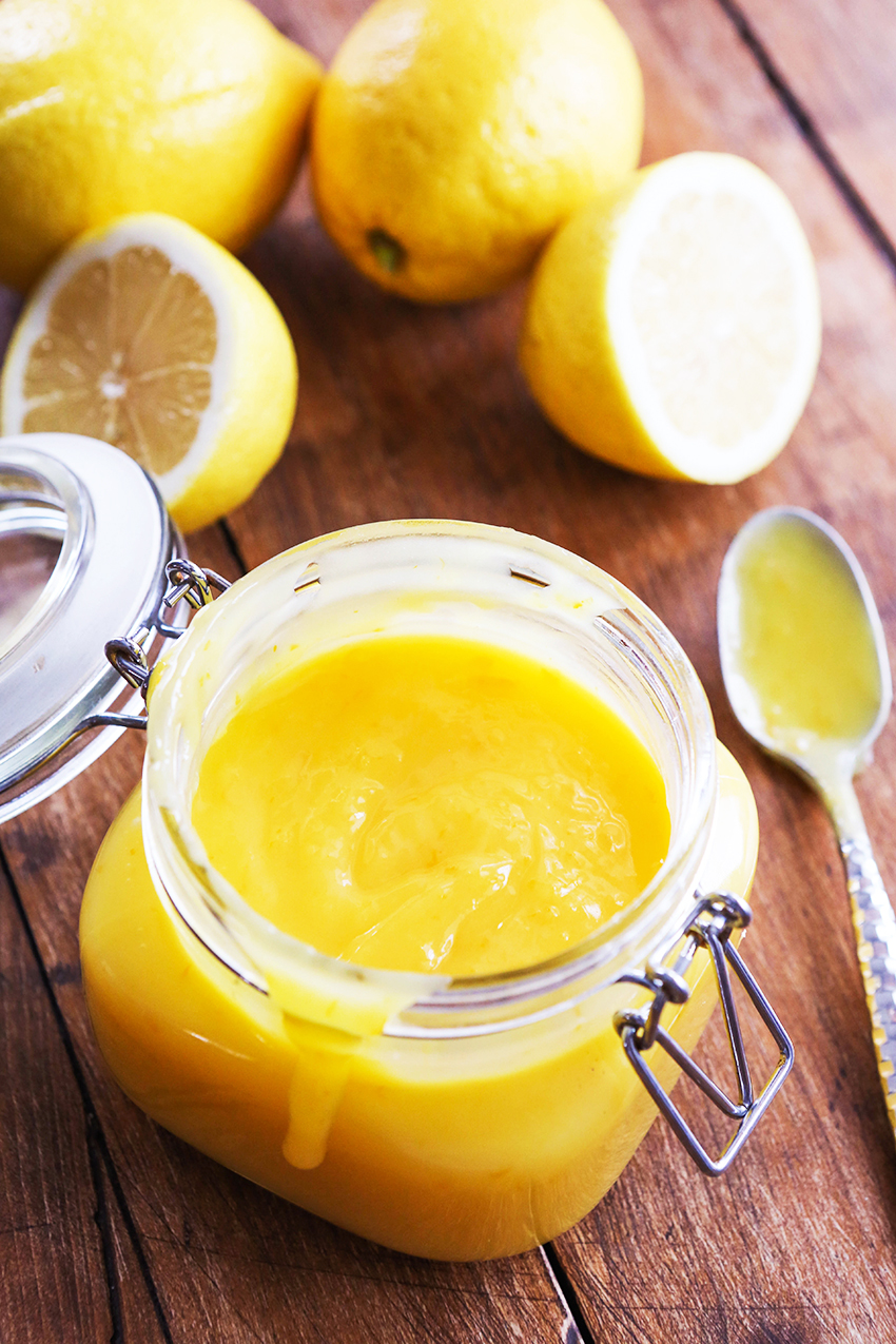 jar of lemon curd surrounded by lemons