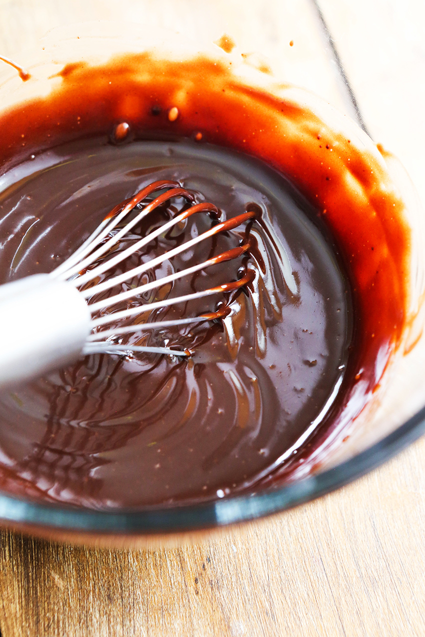 whisk sticking out of a creamy bowl of chocolate ganache